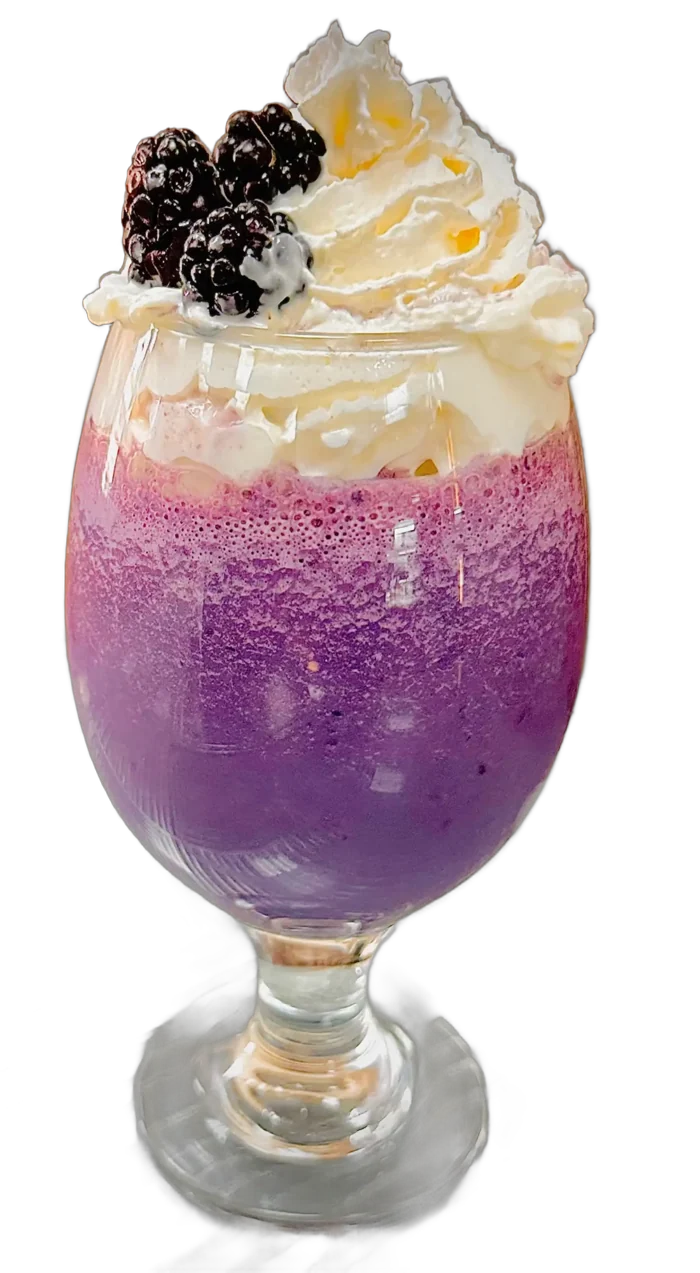 A purple frozen drink in a stemmed glass topped with whipped cream and three blackberries