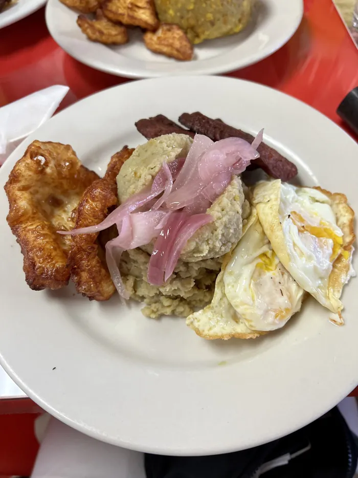 Mangú with fried salami, fried cheese, eggs and pickled red onions
