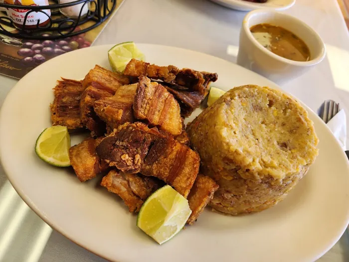 Mofongo with fried pork chicharrón and lime